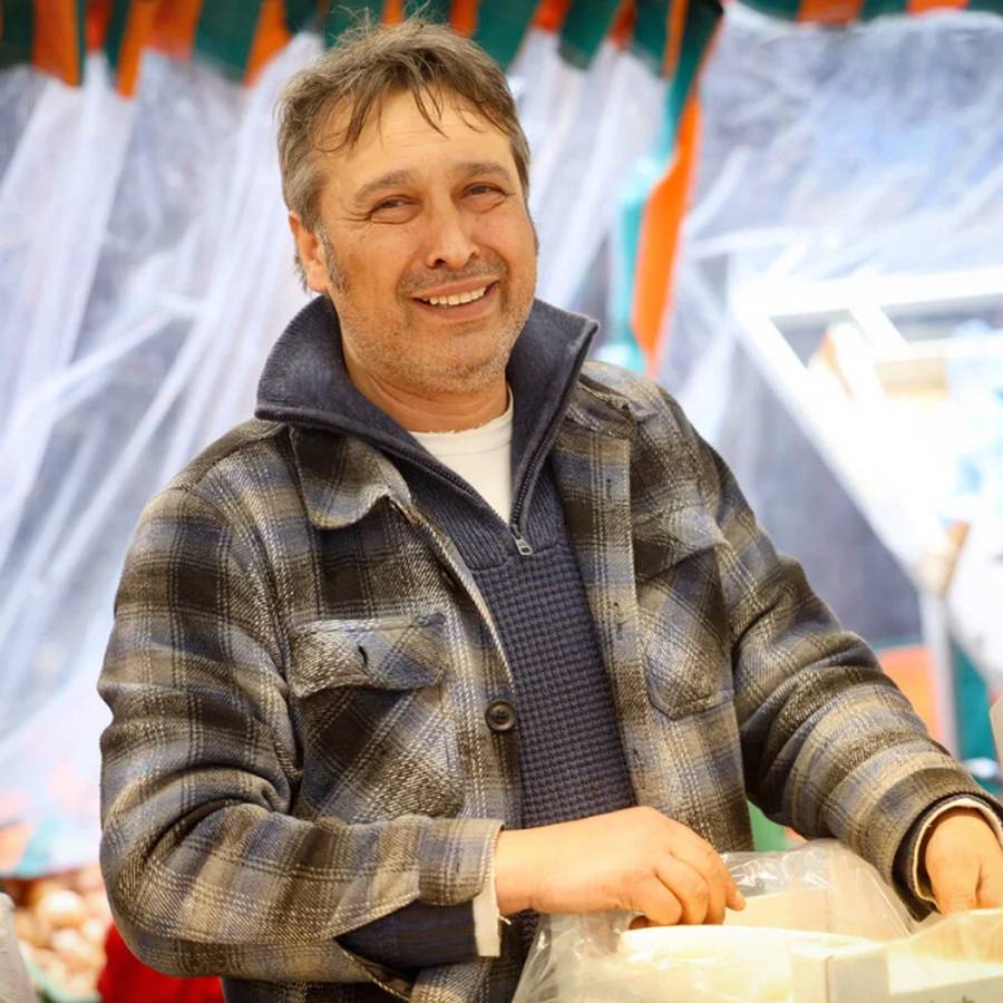 Der Inhaber hinter der Theke des Marktstands